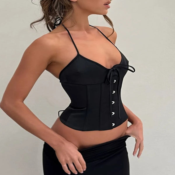 Woman wearing a black corset against a plain background