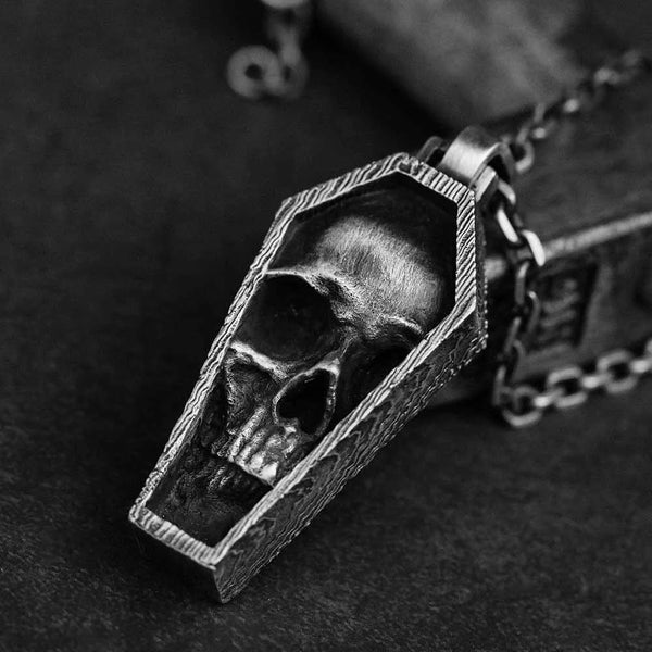 Skull-shaped pendant in a coffin design on a dark background